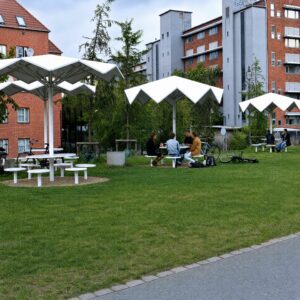 Mobilier urbain blanc parasols géométriques, Parc Vert Superkilen, convivialité et rencontre, aménagement paysager Copenhague, design inclusif.