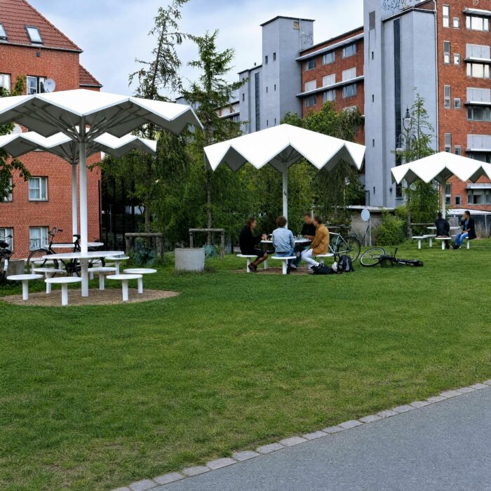 Mobilier urbain blanc parasols géométriques, Parc Vert Superkilen, convivialité et rencontre, aménagement paysager Copenhague, design inclusif.